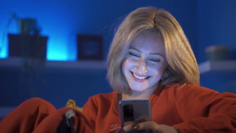 Young-woman-texting-with-boyfriend-and-very-happy.-home-at-night.